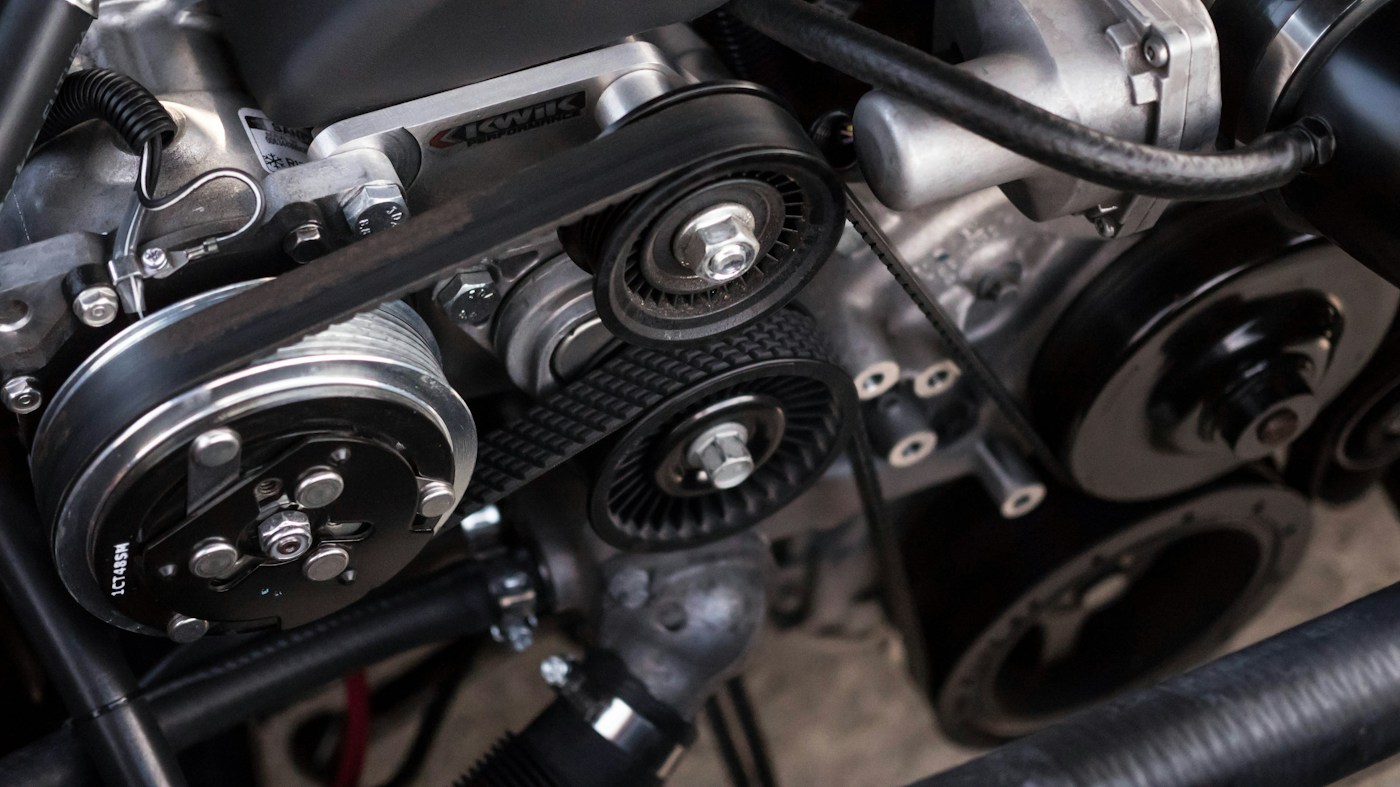 Belts and pulleys in an open vehicle engine bay